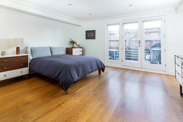 bedroom with light wood-style flooring, crown molding, baseboards, and access to outside