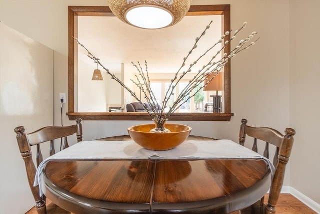 dining area with baseboards and wood finished floors