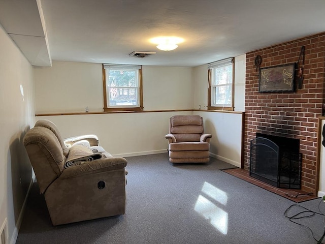 sitting room with visible vents, plenty of natural light, a brick fireplace, and baseboards