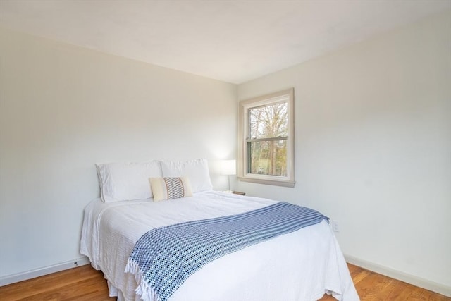 bedroom featuring baseboards and wood finished floors