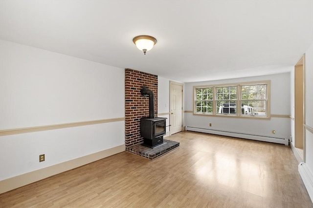 unfurnished living room with a wood stove, light wood finished floors, and a baseboard heating unit