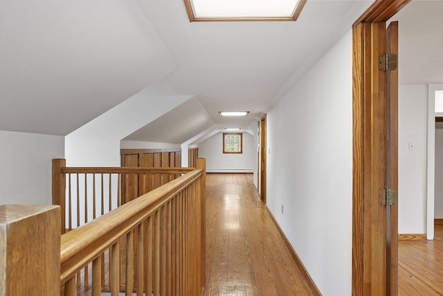additional living space featuring lofted ceiling, light wood-style flooring, a baseboard radiator, and baseboards