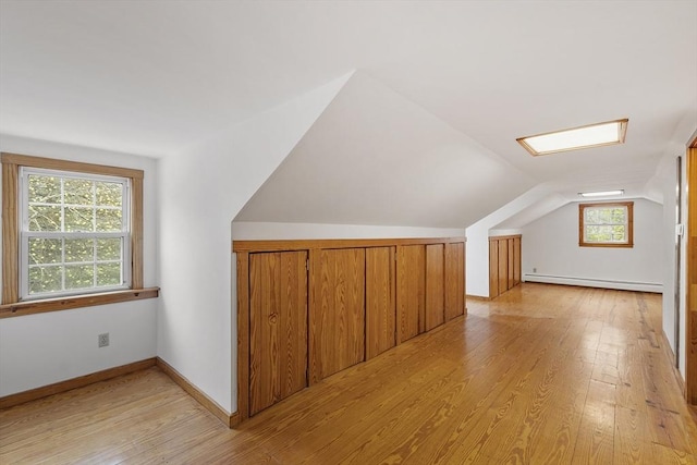 bonus room featuring lofted ceiling, baseboard heating, and light wood-style flooring