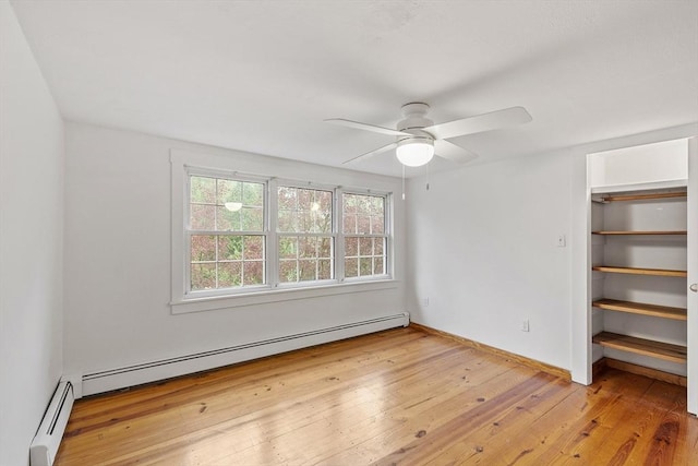 unfurnished bedroom with a ceiling fan, baseboard heating, a baseboard heating unit, baseboards, and hardwood / wood-style flooring