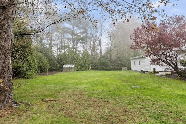 view of yard with an outdoor structure and a greenhouse