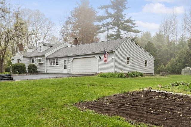 exterior space with an attached garage, a shingled roof, a chimney, and a front lawn