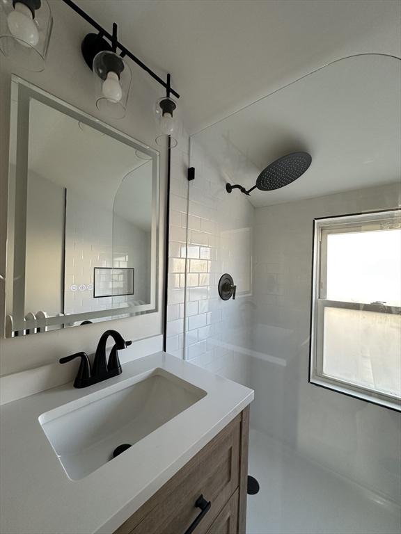 bathroom featuring vanity and a shower