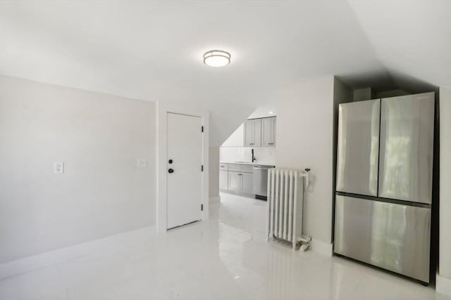 interior space featuring marble finish floor, radiator heating unit, baseboards, and vaulted ceiling