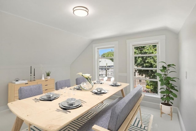 dining room with baseboards and lofted ceiling