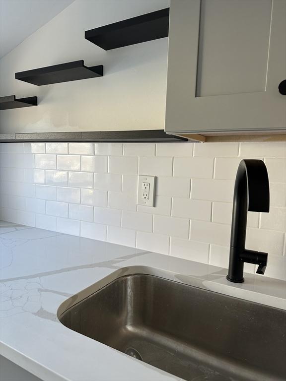 details featuring light stone counters and a sink