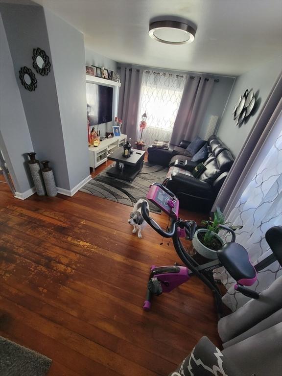 living area with baseboards and wood finished floors