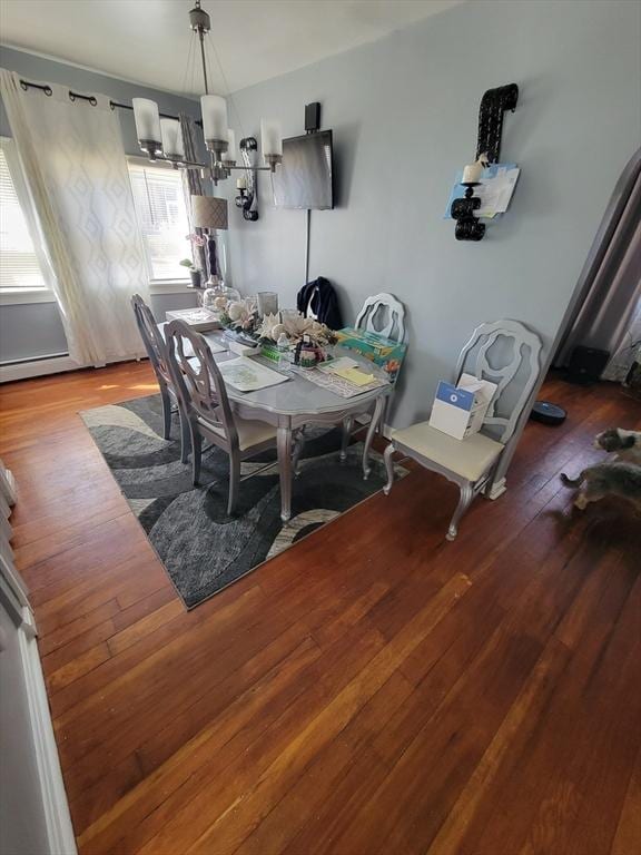 dining space with a notable chandelier and hardwood / wood-style flooring