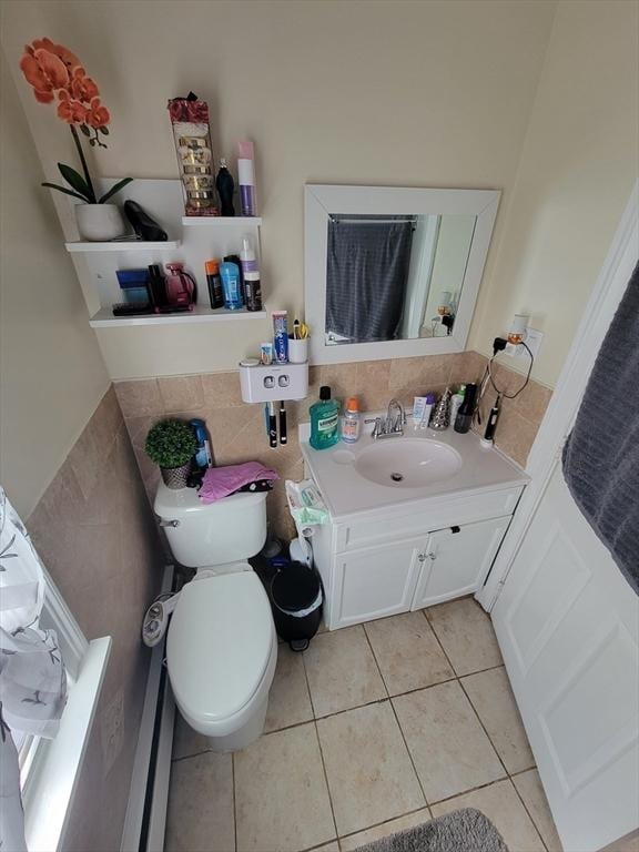 bathroom with tile patterned floors, toilet, vanity, and tile walls