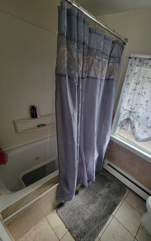 bathroom featuring tile patterned flooring, a shower with curtain, and a baseboard radiator