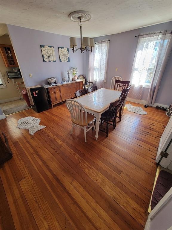 dining space featuring a notable chandelier, light wood-type flooring, and baseboards