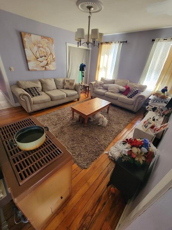 living area with an inviting chandelier and hardwood / wood-style flooring