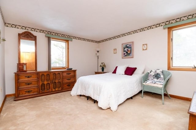 bedroom with light carpet and baseboards