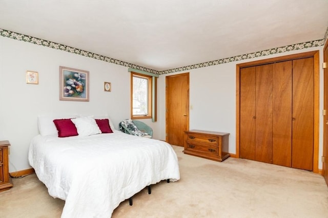 bedroom with baseboards and light colored carpet