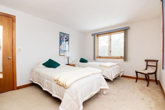 bedroom featuring light colored carpet and baseboards