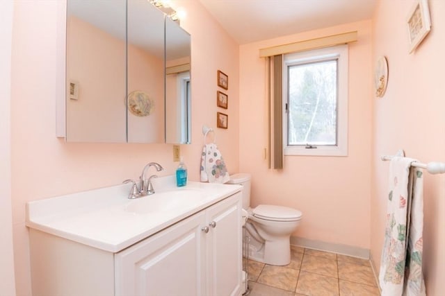 bathroom with toilet, tile patterned flooring, baseboards, and vanity