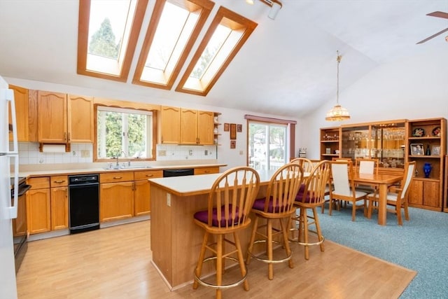 kitchen with plenty of natural light, a center island, light countertops, and a sink