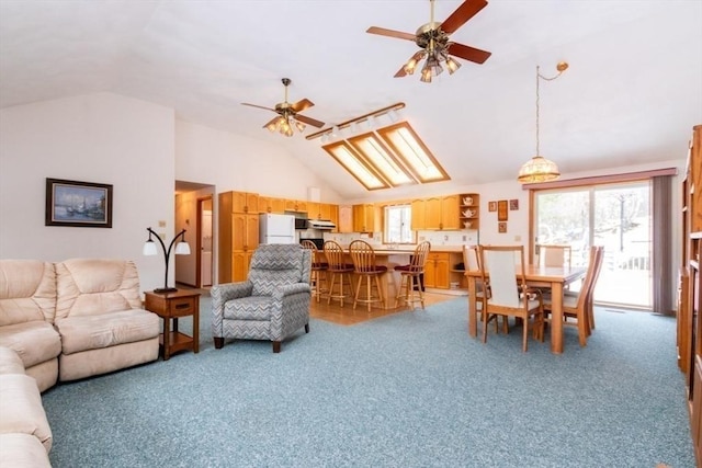 living area featuring light carpet, vaulted ceiling, and ceiling fan