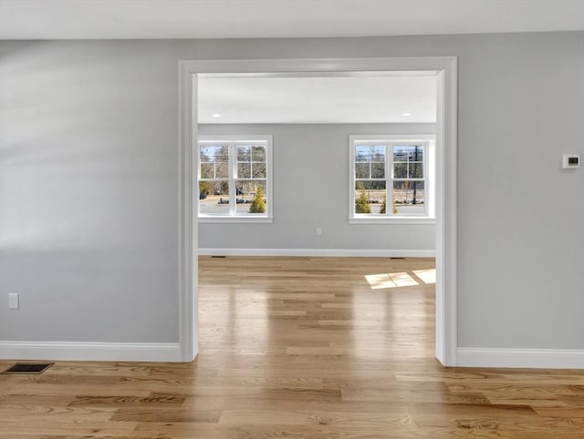 hallway featuring a wealth of natural light, baseboards, and wood finished floors