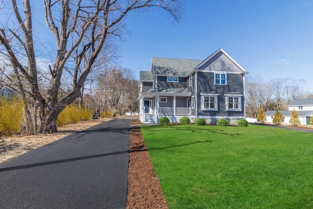 view of front of house with driveway and a front lawn