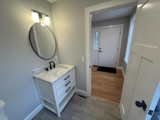 bathroom featuring vanity, wood finished floors, visible vents, and baseboards