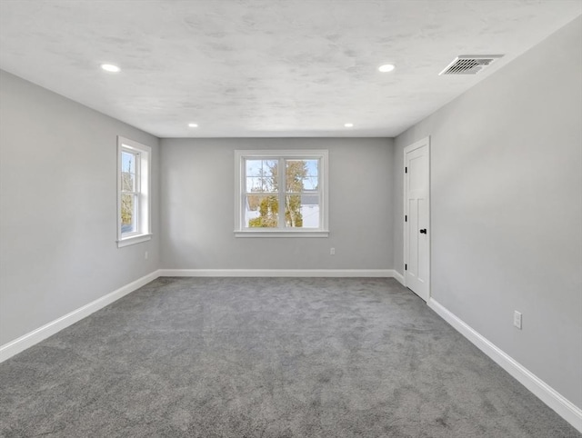 carpeted empty room featuring recessed lighting, baseboards, and visible vents