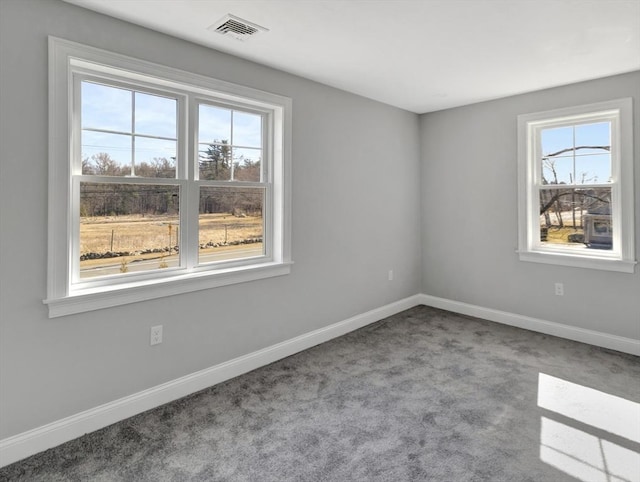 unfurnished room featuring visible vents, baseboards, and carpet floors