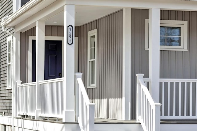 doorway to property featuring board and batten siding and covered porch