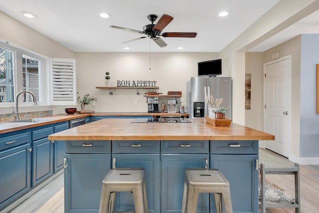 585 Sheridan St Unit 8, Chicopee, MA 01020 - kitchen featuring stainless steel fridge with ice dispenser, black electric cooktop, a sink, wood counters, and blue cabinets