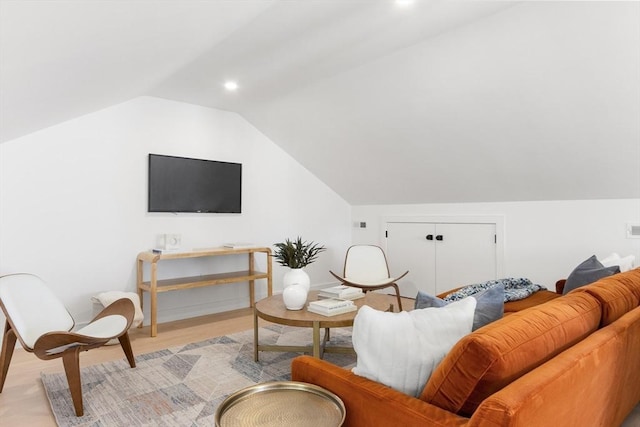 living room featuring vaulted ceiling and light hardwood / wood-style flooring