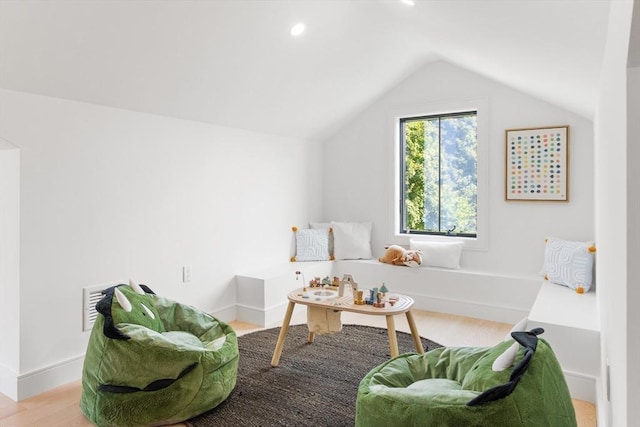 living area featuring light hardwood / wood-style floors and vaulted ceiling