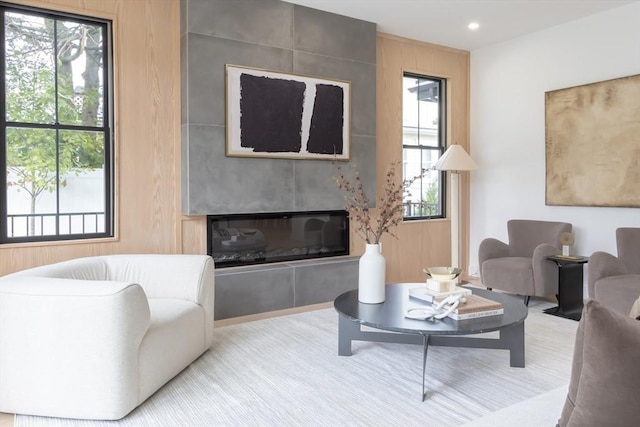 living room with a fireplace and wood walls