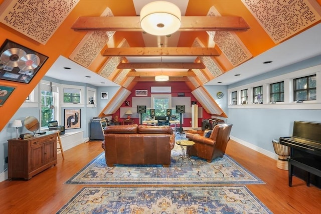 living area with wood finished floors, baseboards, and high vaulted ceiling