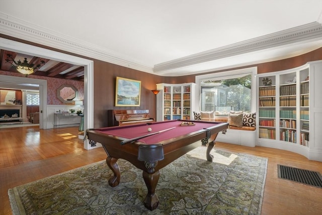 game room with crown molding, wood finished floors, pool table, built in features, and wallpapered walls