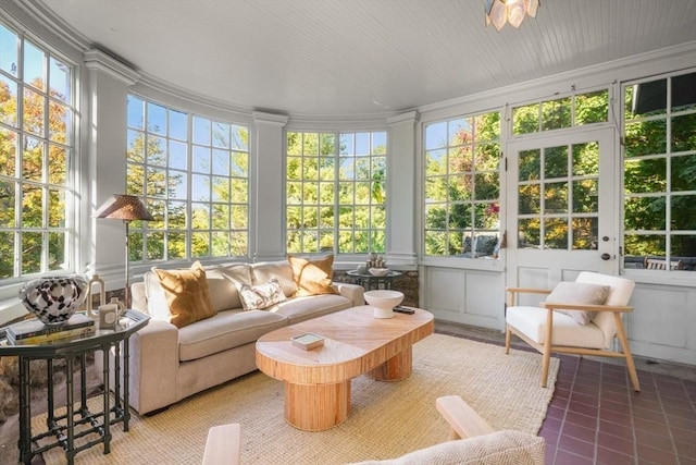 sunroom / solarium featuring plenty of natural light and crown molding