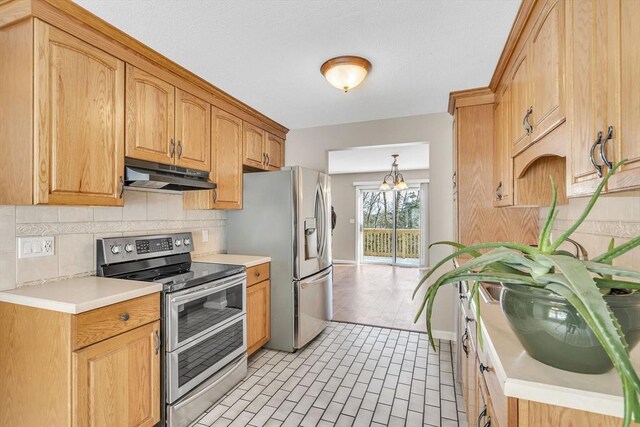 kitchen with stainless steel appliances, tasteful backsplash, and hanging light fixtures