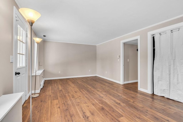 spare room featuring hardwood / wood-style floors and crown molding