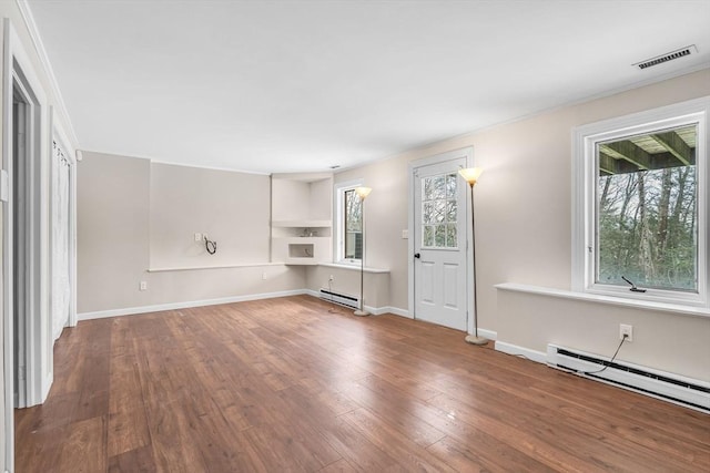 unfurnished living room with wood-type flooring and a baseboard heating unit