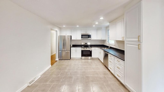 12 Sandra Ave, Burlington, MA 01803 - kitchen with appliances with stainless steel finishes, dark countertops, white cabinetry, and recessed lighting