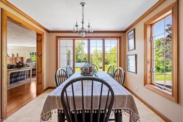 dining space featuring light hardwood / wood-style floors, a healthy amount of sunlight, an inviting chandelier, and crown molding