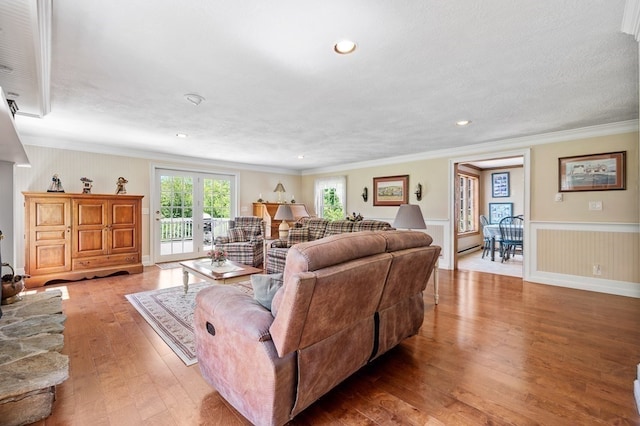 living room with crown molding, light hardwood / wood-style flooring, and a textured ceiling