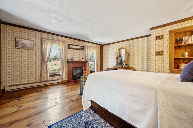 bedroom with ornamental molding, baseboard heating, a textured ceiling, and wood-type flooring