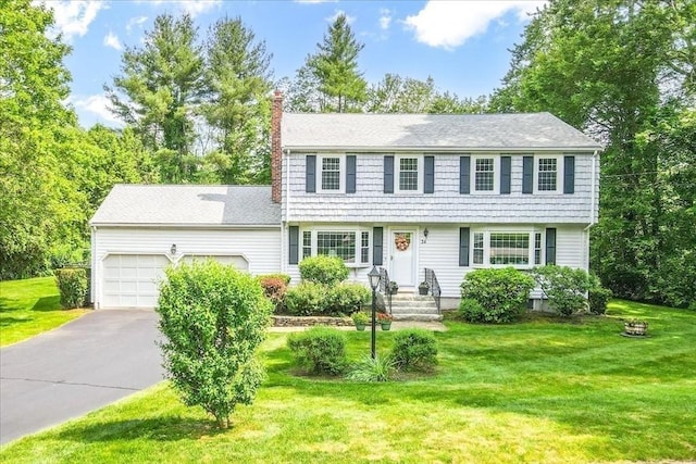 24 Stagecoach, Medfield, MA 02052 - colonial house featuring a chimney, a garage, asphalt driveway, and a front yard