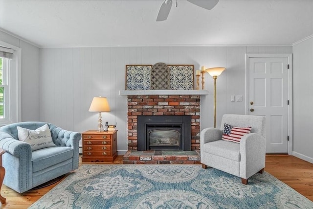 24 Stagecoach, Medfield, MA 02052 - sitting room featuring wood finished floors, a ceiling fan, a brick fireplace, ornamental molding, and baseboard heating