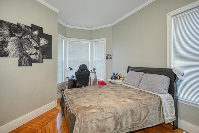 bedroom featuring crown molding, wood finished floors, and baseboards