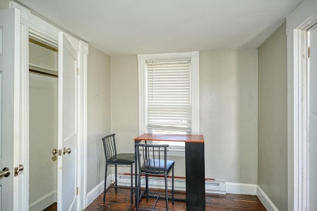 interior space with baseboards, a baseboard heating unit, and dark wood-type flooring